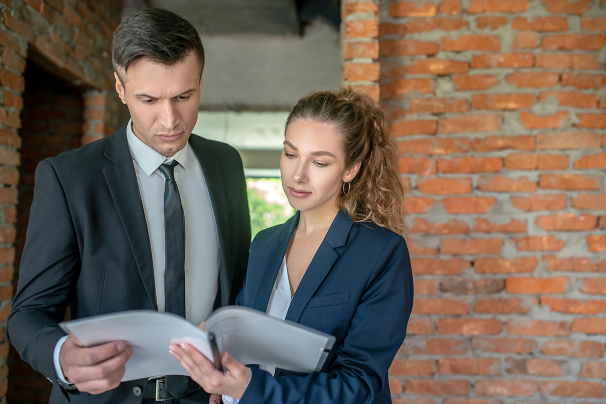 Male investor in a black suit reading a contract