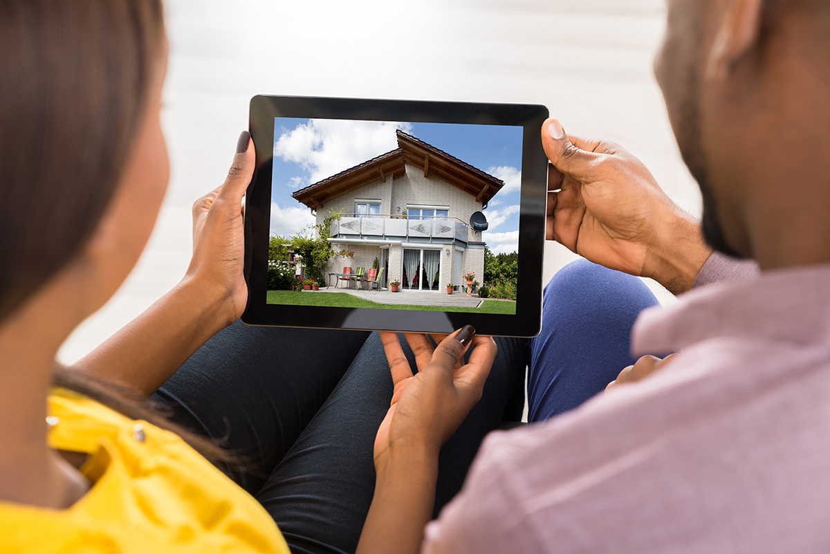 Couple looking at a home on a digital tablet