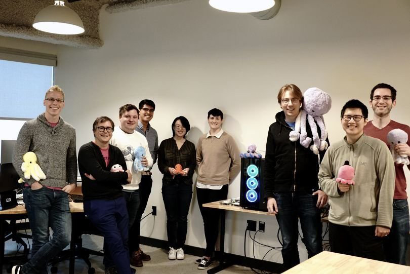 Group photo of OctoML team members holding plush octopuses