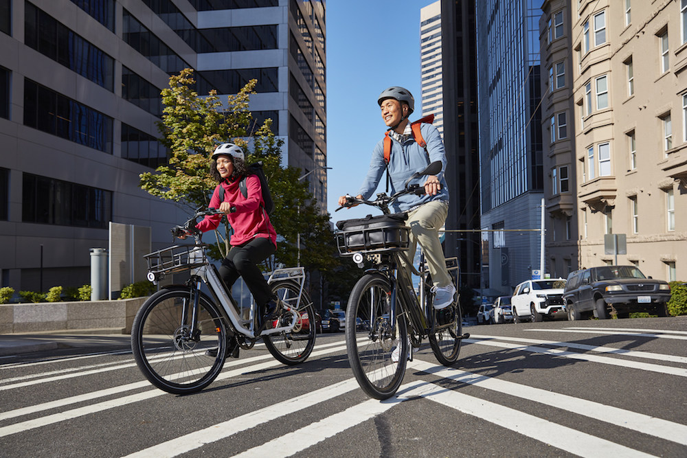 two people riding Rad Power bikes in a city