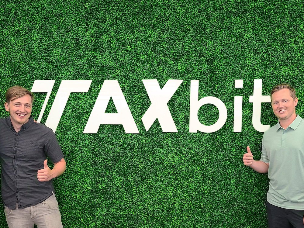 TaxBi co-founders in front of TaxBit sign