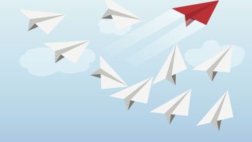 Paper airplanes soaring in formation. A red paper airplane soars ahead.