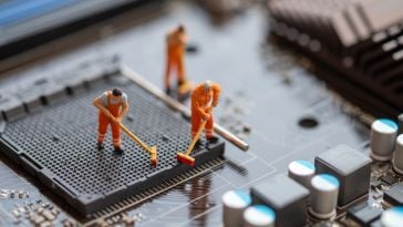 Tiny figurines clean the inside of a computer.