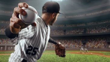 A baseball pitcher reeling back to throw. The camera is focused in on a baseball.
