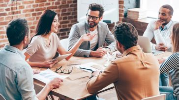 Coworkers having a discussion sitting at a table at the office