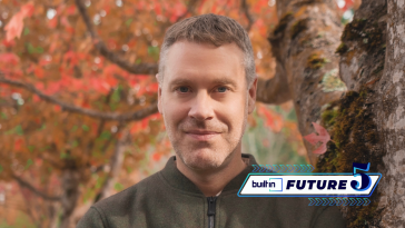 Tom Lapham, CEO of CHEQ, poses for a photo outside by a tree with changing leaves