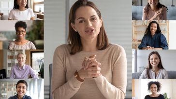 Screen shot of woman in beige sweater in center panel with eight smaller screens of people flanking her.