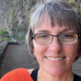 This is Wendy. A headshot of a woman taken in front of a rock wall.